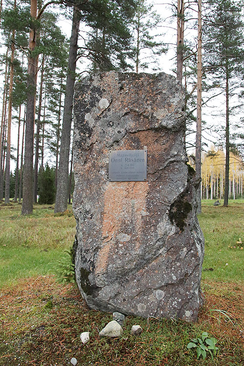 Muistomerkki on kivipaasi mäntyjen keskellä
