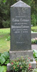 Pysty ja korkea hautakivi.