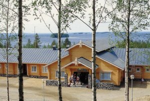 Iso hirsirakennus rinteessä, takana siintää Höytiäisen selkävesi.