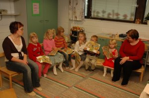 Kaksi ohjaajaa ja lasia istumassa kerhotilassa.