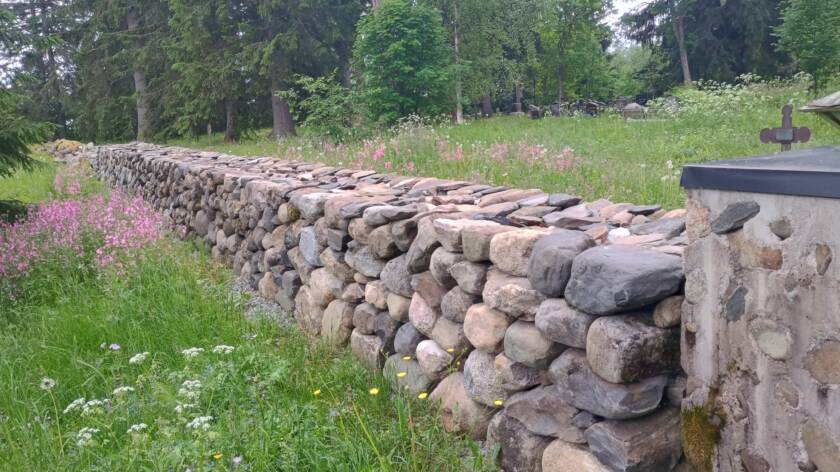 Kukkaniityn keskellä on hautausmaan kunnostettu kiviaita.