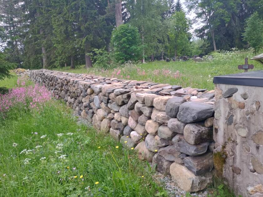 Kukkaniityn keskellä on hautausmaan kunnostettu kiviaita.