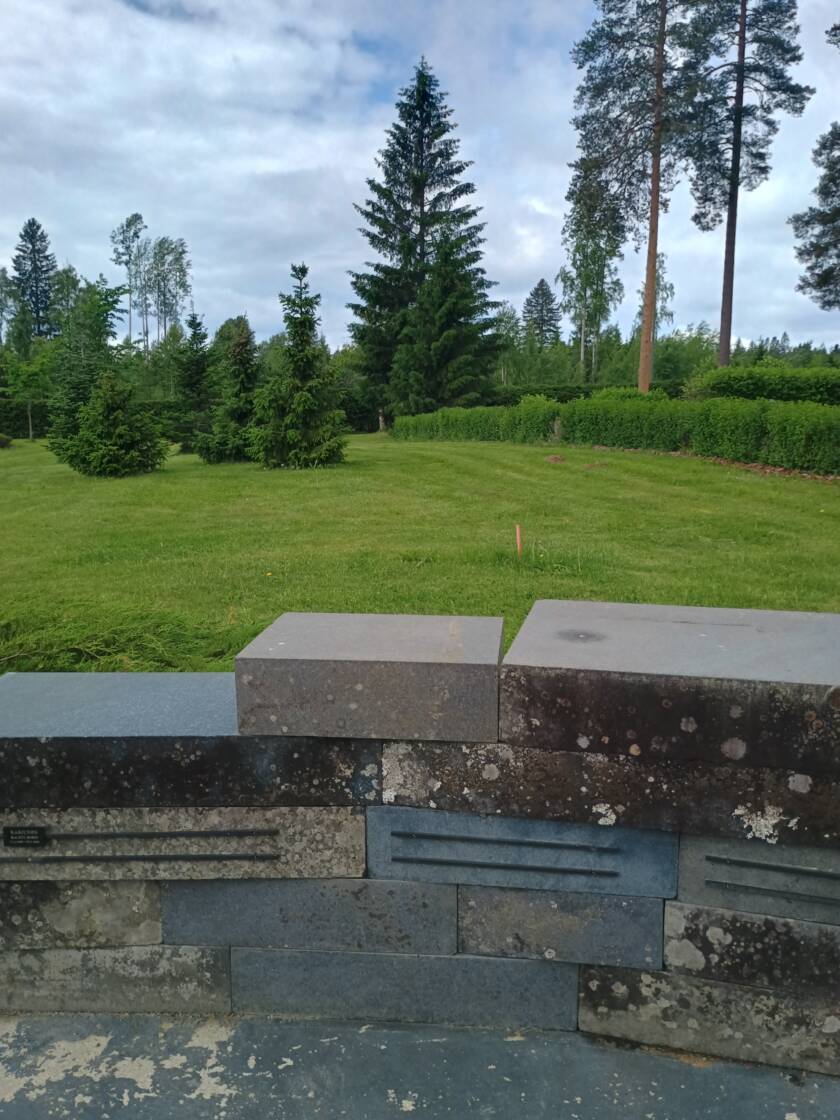 Käytöstä poistettuja hautakiviä nurmikon vieressä.