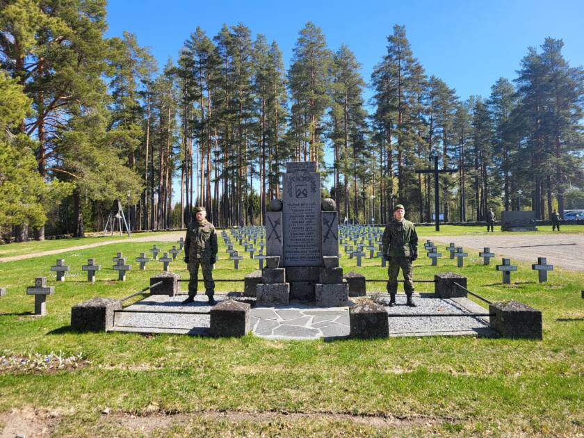 Kaksi sotilasta seisoo asennossa sankarihautausmaan muistomerkin molemmin puolin.