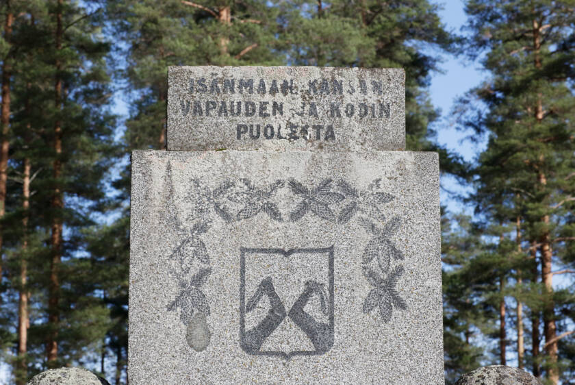 Muistomerkin yläosaan on kaiverrettu kuvioita ja teksti isänmaan, kansan, vapauden ja kodin puolesta.